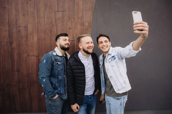 Amis heureux prendre un selfie à côté du mur — Photo