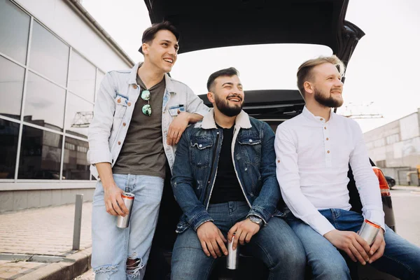 Un montón de amigos hablando en el maletero del coche. Verano. —  Fotos de Stock