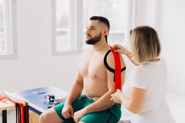 요법사 상처를 어깨를 환자에게 사용하는 니시오 테이프 — 스톡 사진
