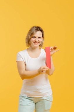 Sarı arka planda göstermek için bir terapist kineziyoloji bandı çekiyor. Alternatif kinesio bant terapisi, sağlık hizmeti konsepti