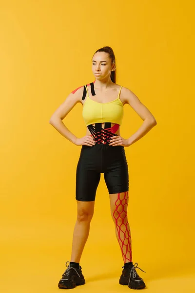 Young Caucasian Girl Kinesiology Tape Her Belly Leg Yellow Background — Stock Photo, Image