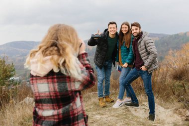 Genç bir kadın eski fotoğraf makinesiyle fotoğraf çekiyor.