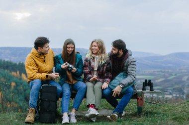 Bir grup mutlu genç gezgin doğanın tadını çıkarıyor.