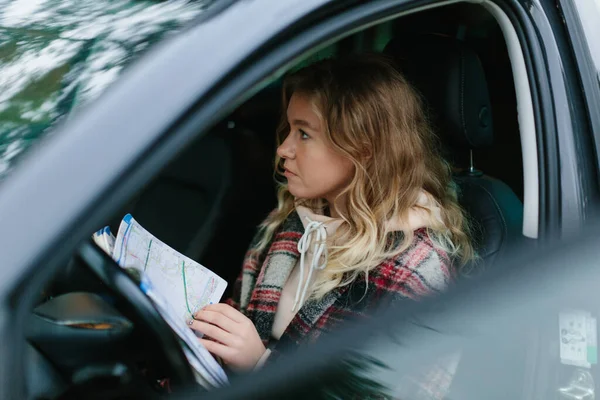 Νεαρή Γυναίκα Κάθεται Στο Αυτοκίνητο Και Κρατώντας Χάρτη — Φωτογραφία Αρχείου