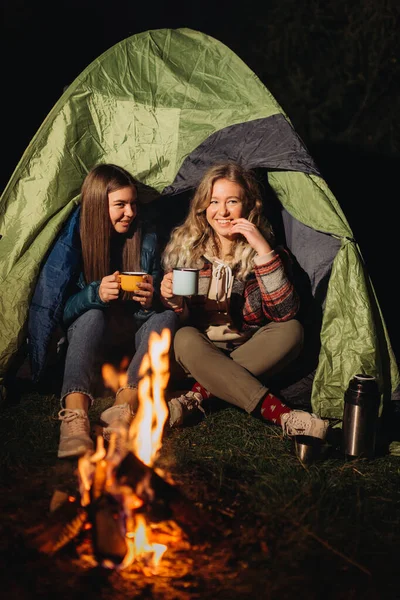 Gece vakti şenlik ateşinin önünde oturan yoldaşlar. 