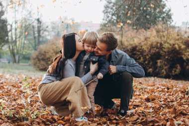 Sonbahar parkında oynayan aile...