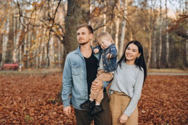 Mutlu aile babası ve bebeği parkta sonbahar yürüyüşünde.