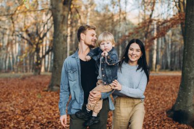 Mutlu aile babası ve bebeği parkta sonbahar yürüyüşünde.