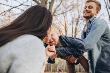 Sonbahar parkında oynayan aile...