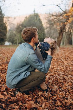 Mutlu baba ve oğul sonbahar parkında eğleniyor.