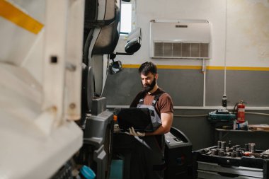 Otomatik mekanik iyi donanımlı bir atölyede bir kamyon motorunu ustalıkla tamir ederek, ideal araç performansı için teşhis ve bakım üzerinde odaklanır