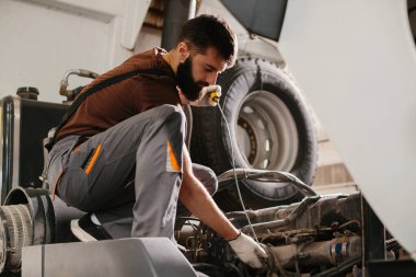 Profesyonel bir garaj ayarında tamirat ve bakım yapan yetenekli bir araba tamircisi.
