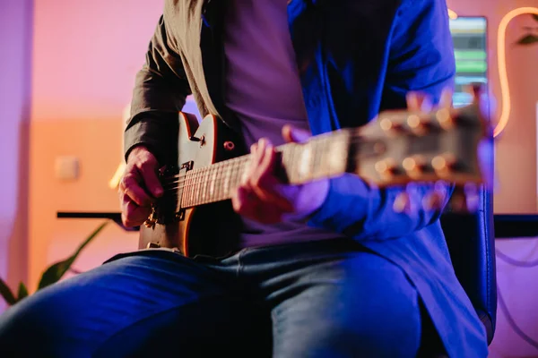 Genç müzisyen, ilham ve sanatsal enerjiyle dolu canlı bir ev stüdyosunda elektro gitar çalarken yeni melodiler yaratıyor.