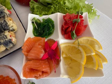 Kırmızı balık havyarı limonlu wasabi zencefilli deniz yosunu chuka kırmızı balık masası çiçeklerle süslenmiş ve mikro yeşil limon, eko ve doğal beslenme gıdalarıyla süslenmiş. 4 bin. Yüksek kalite 4k görüntü