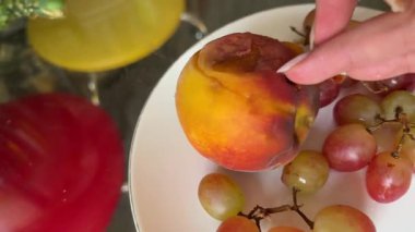 rotten spoiled peach near grapes on a plate of midges. High quality 4k footage