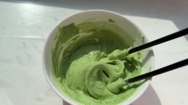 Bright green grated horseraddish wasabi spicy sauce texture circle rotation close up top view. High quality 4k footage