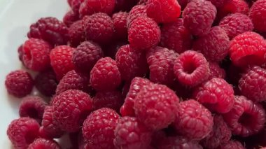 Pile of fresh red raspberries rotating. Sweet harvest. Organic vitamin product. Juicy raspberries. Stack of berries. Vertical video. Fruit pattern. Concept of healthy food. 