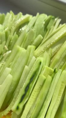 Cutting fresh cucumber into slices with special fruit and vegetable knife. Woman slicing green cucumber with precision tool. Preparing healthy cucumber slices on kitchen table. High quality 4k footage