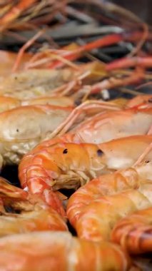 Chef cooking shrimps with oil and spices on grill close-up. Prawns on fire throwing them on pan. Dorado and salmon fish steak on frying grill. Restaurant Food concept. Sea food.