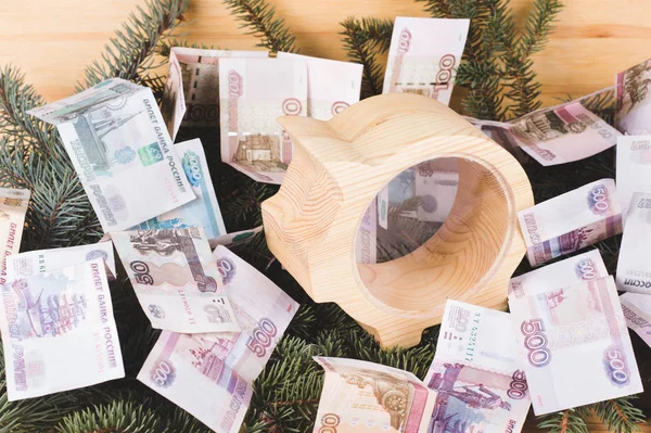 ロシアのルーブル紙幣で黄色木製貯金スプルースの枝でクリスマスとお正月の背景 建具ワーク ショップ商品 ストック写真