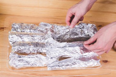 Lezzetli Fırında Balık cam tepsi ahşap masa üzerinde folyo. Sağlıklı beslenme kavramı