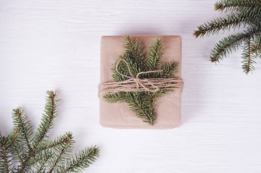 Noel hediye kutusu beyaz ahşap zemin üzerinde. Çerçeve köknar dalı,