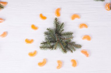 Köknar şubelerinde şeklinde ağaç ve ahşap beyaz zemin üzerine çevresine mandalina. Noel ve yeni yıl kompozisyon.