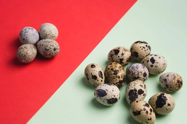 heap of quail eggs on green and red background. Vegetarian organic  food. Eco product concept. Top view. flatlay