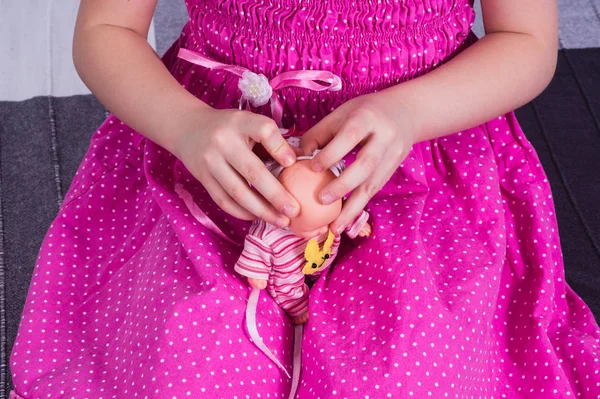 Маленька дівчинка одягає ляльку. концепція дитинства та догляду — стокове фото
