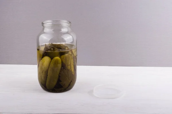 Pot en verre avec des concombres marinés sur fond gris avec copie sp — Photo