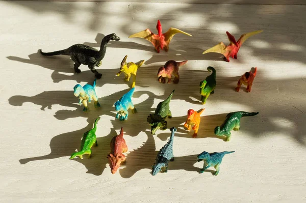 Figures de dinosaures placées dans un soleil éclatant, et leurs ombres — Photo