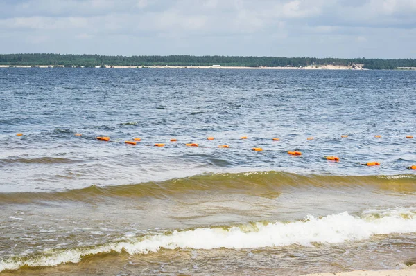 Praia da cidade arenosa com pequenas ondas e bóias. ondas do rio — Fotografia de Stock