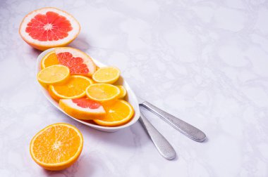 Beyaz arka planda taze meyveli turunçgil tabağı. Yüksek miktarda antioksidan, vitamin, diyet lifleri ve antocaynin..