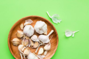 Sarımsak soğanı. Yeşil arka planda sarımsaklı karanfil.