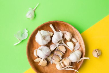 Sarımsak soğanı. Sarı-yeşil arka planda sarımsak karanfili.