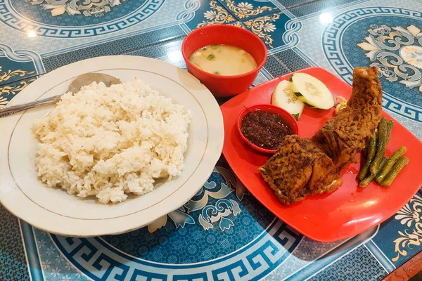 Yemek masasında pilav, çorba, kızarmış balık.