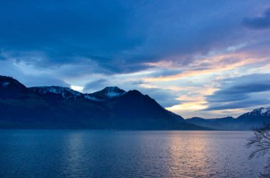 Kışın Alpler 'de bir gölün üzerinde fantastik mavi bir alacakaranlık.