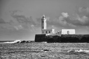 Dalgalı okyanusta siyah beyaz deniz feneri