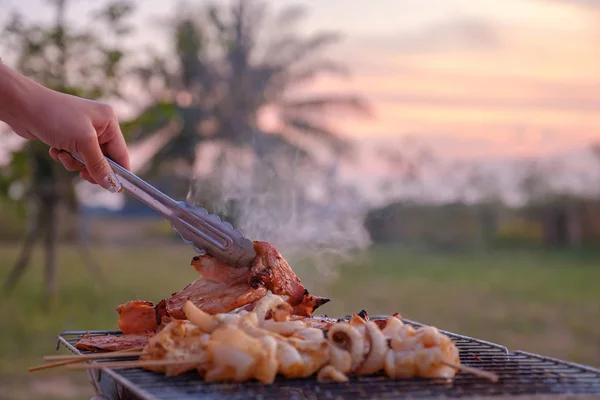 Biri bahçede barbekü ızgara yemek ızgara.