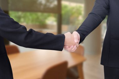 Erkek ve kadın ofiste el sıkışıyor..