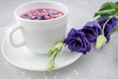 Bitki çayını yapraklar, kuru böğürtlenler ve meyvelerle karıştır. Sağlıklı içecek. Sıcak meyve, beyaz bardakta sağlıklı çay.