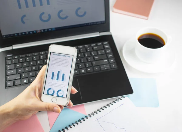 Minimalistic workplace concept, with a laptop, pen and business work records on a white background. Image of business plan, startup. Close up image