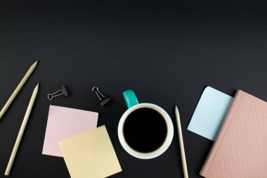 Minimalist iş yeri konsepti, akıllı telefon, kalem ve iş kayıtlarıyla karanlık bir geçmişe sahip. Görüntü dijital, pazarlama, tasarım ajansı. Üst Manzara. Düzleştirme biçimi.