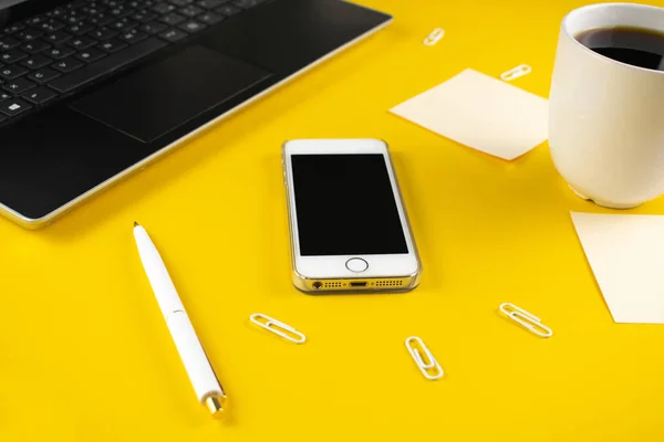 Concepto minimalista de lugar de trabajo, con un smartphone, bolígrafo y registros de trabajo de negocios sobre un fondo amarillo. Agencia digital de imagen, educación en línea. Cerrar imagen — Foto de Stock