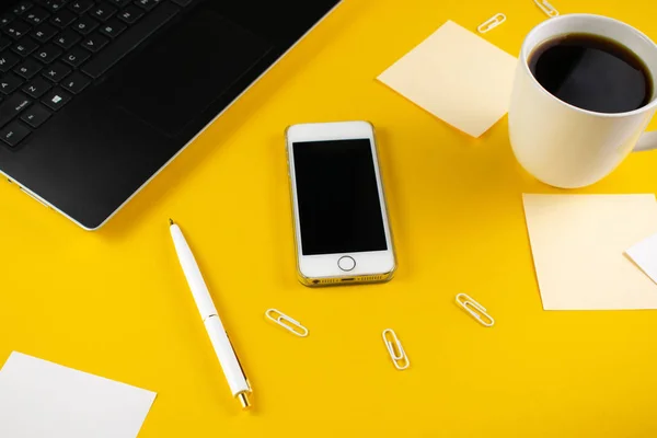 Conceito minimalista de local de trabalho, com um smartphone, caneta e registros de trabalho de negócios em um fundo amarelo. Imagem agência digital, educação online. Vista superior. Flat lay estilo. — Fotografia de Stock