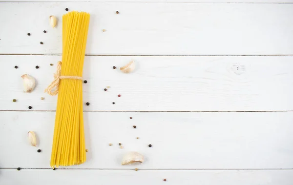 Monte de espaguete seco longo em uma mesa de madeira branca. Conceito de cozinha italiana, ingredientes alimentares. Deitado. Vista superior — Fotografia de Stock