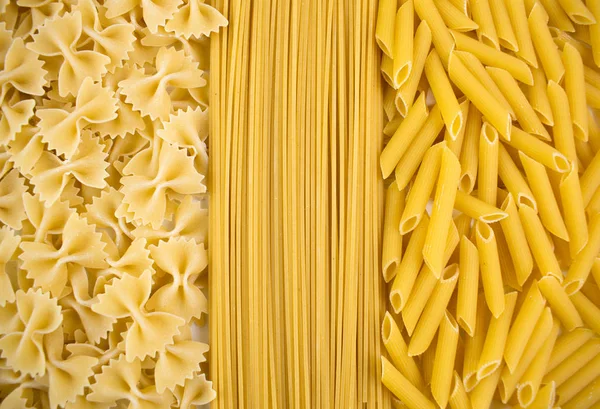 Various types of pasta. background of different dry macaroni. Italian cuisine concept, food ingredients. Flat lay. Top view, copy space