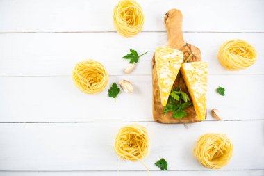 Beyaz ahşap bir masada çeşitli makarna türleri. İtalyan mutfağı konsepti, yemek malzemeleri. Düz yatıyordu. Üst görünüm