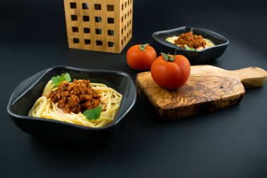 Ahşap arka planda bir tabakta spagetti bolonez. İtalyan mutfağı konsepti, yemek malzemeleri. Görüntüyü kapat