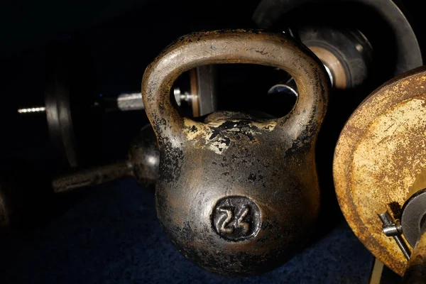 Old and heavy kettlebell weight in dark room.